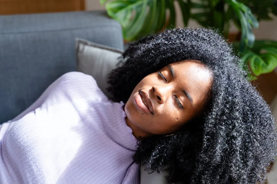 Woman resting peacefully with eyes closed, in a deeply relaxed state